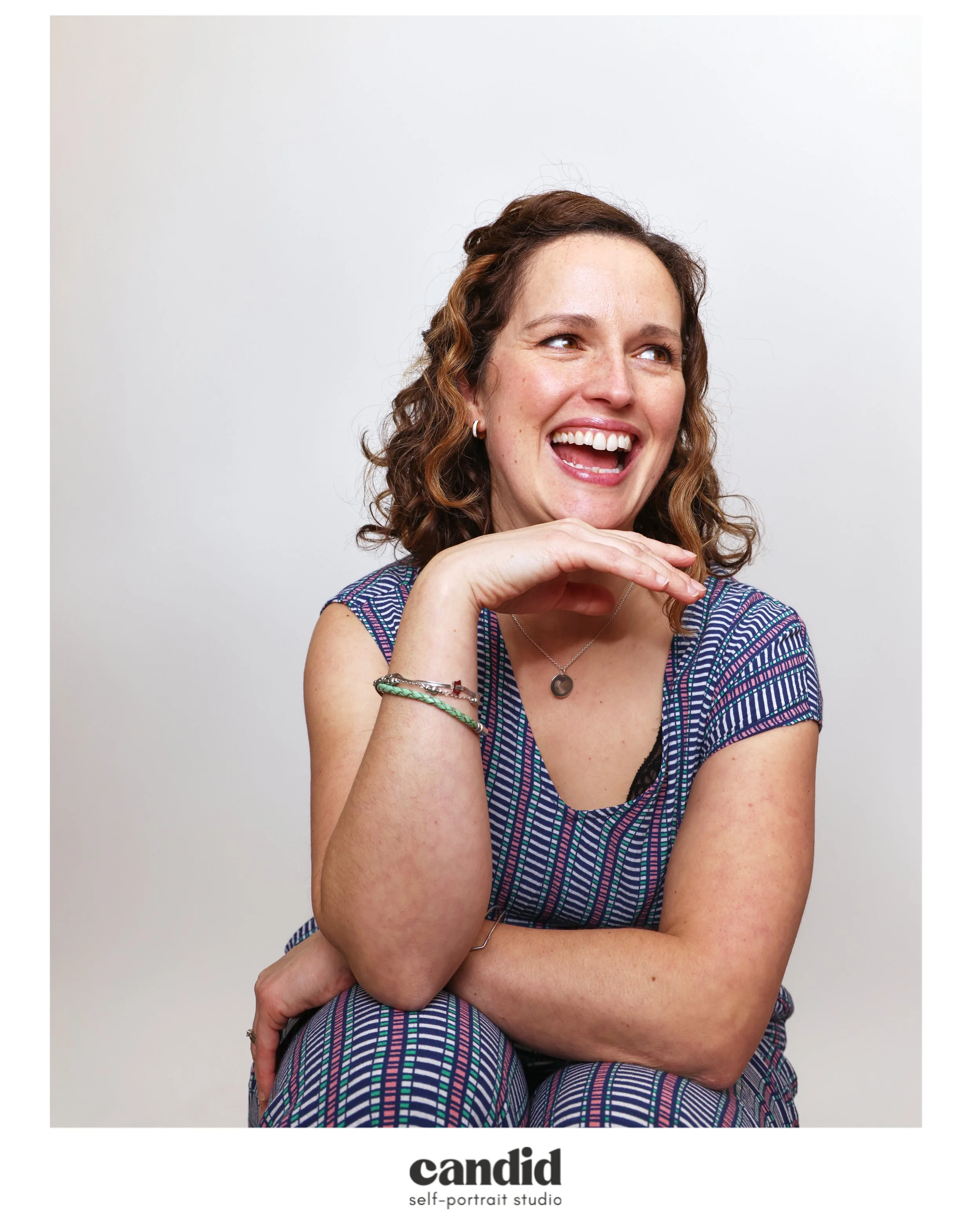 Modern wooden building with large glass window, set in a mountainous landscape, with a person visible inside.
