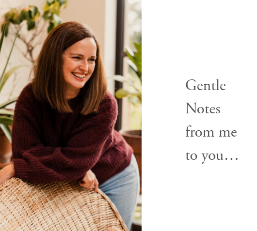 Scenic view of a large lake surrounded by green hills and mountains under a cloudy sky.