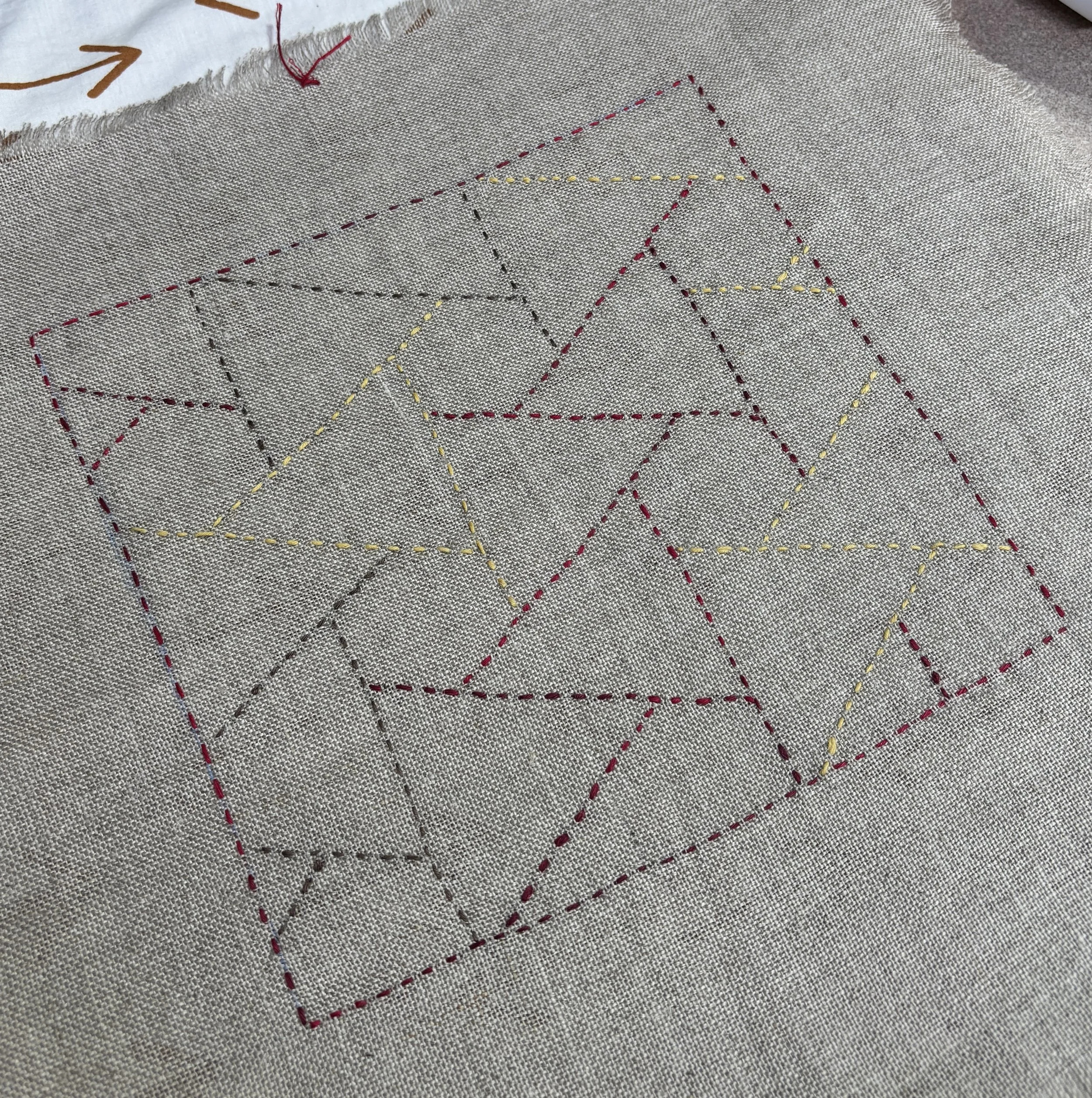 Close-up of fabric with colorful Sashiko embroidery.