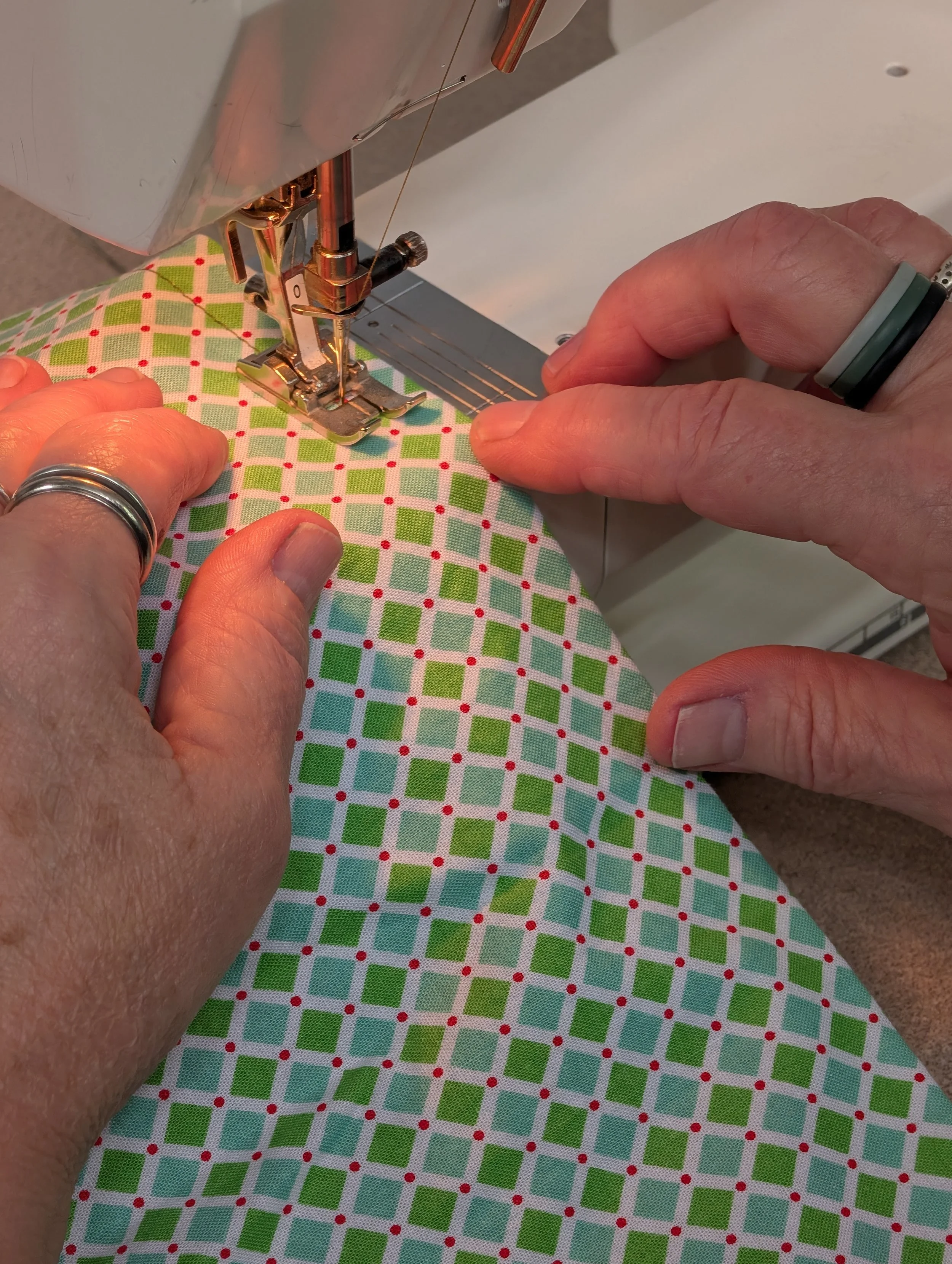 close up of woman sewing on a sewing machine teaching people how to sew