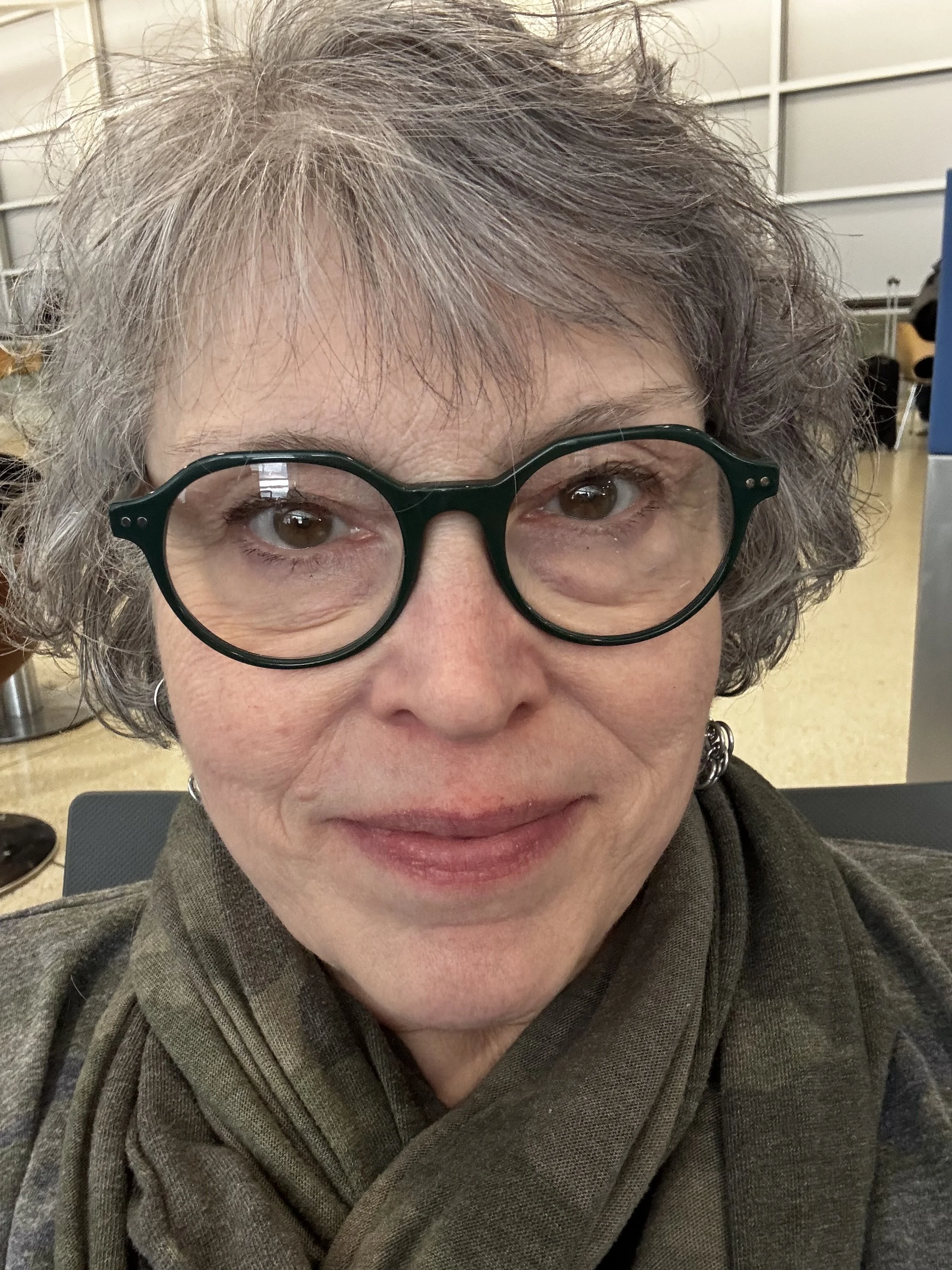 Smiling, older white woman with grey hair and glasses