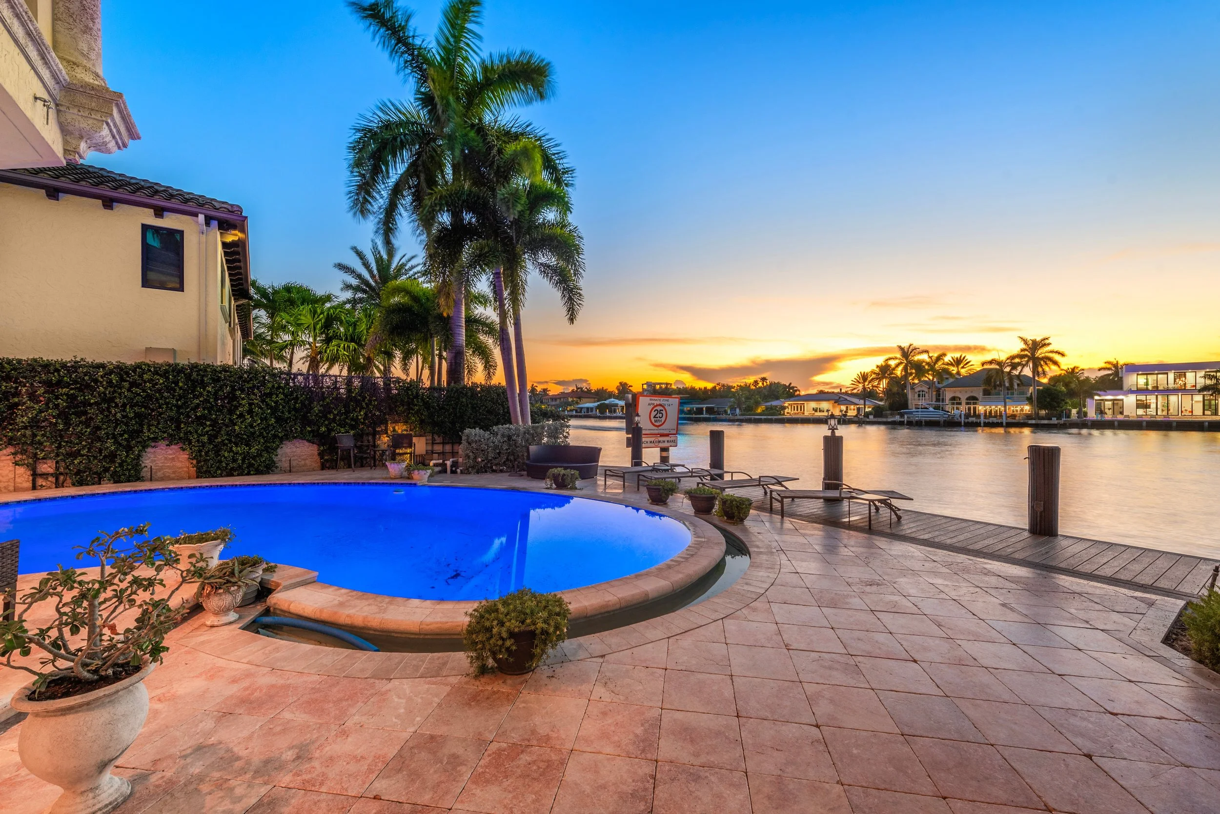 Luxury Florida pool home overlooking a calm residential canal bordered by palm trees in Jacksonville Beach.