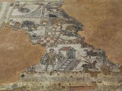 Ancient mosaic floor with damaged and missing tiles, depicting geometric patterns and figures.