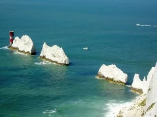 Sea stacks along a coastline with blue water and white cliffs.