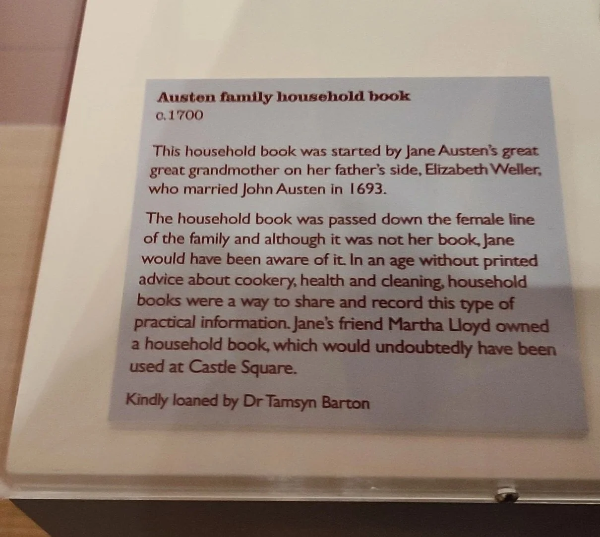Museum display panel about Austen family household book, it mentions Jane Austen's great grandmother Elizabeth Weller and her marriage to John Austen in 1693, and Martha Lloyd, who owned a household book used at Castle Square. The panel is signed by Dr Tamsyn Barton.