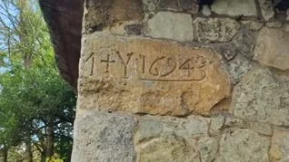 A stone embedded in a brick wall with the inscription '1943 14' or '14 1943' carved into it.