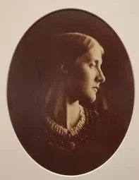 Sepia portrait of a woman with long hair wearing a beaded necklace, shown in profile