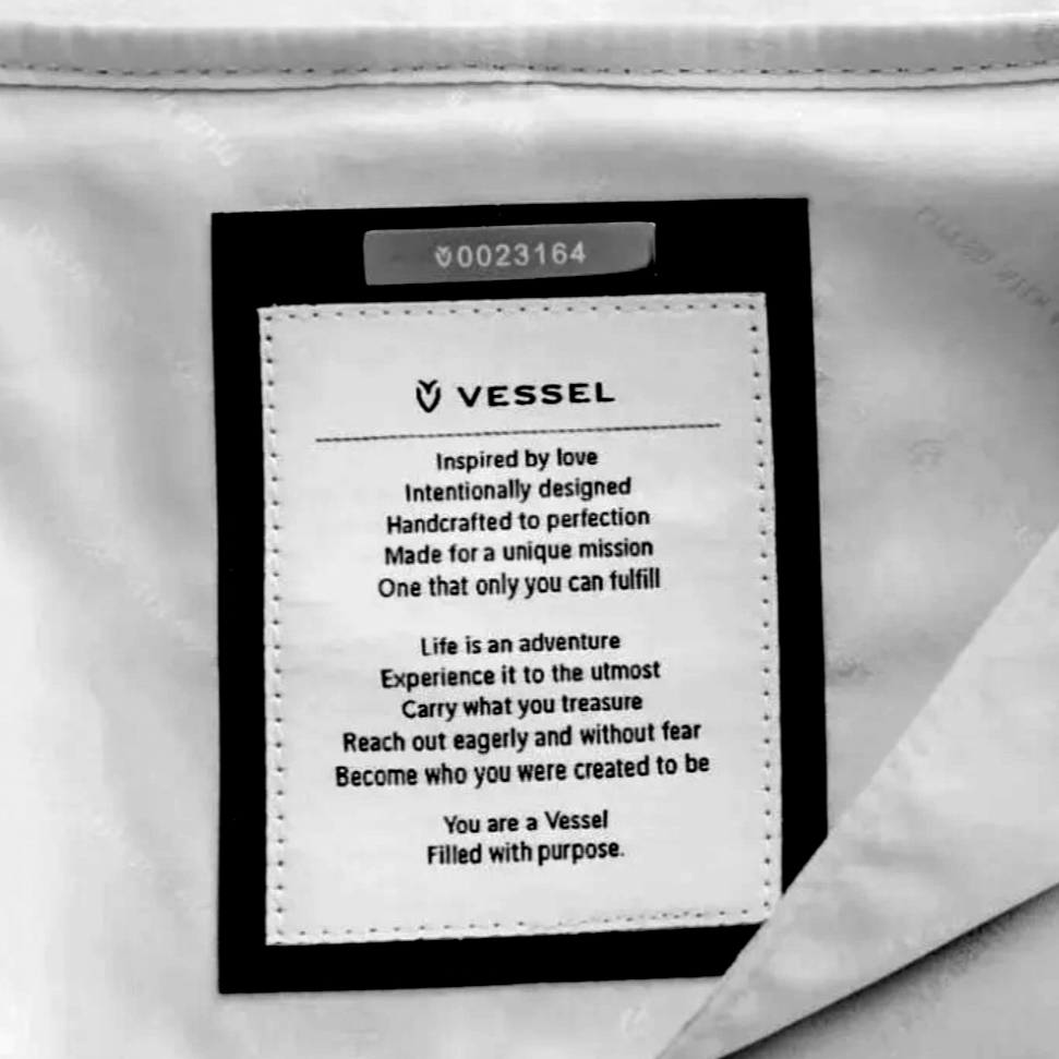 A black card with white text next to a paper bag, featuring a motivational message about being a vessel filled with purpose.