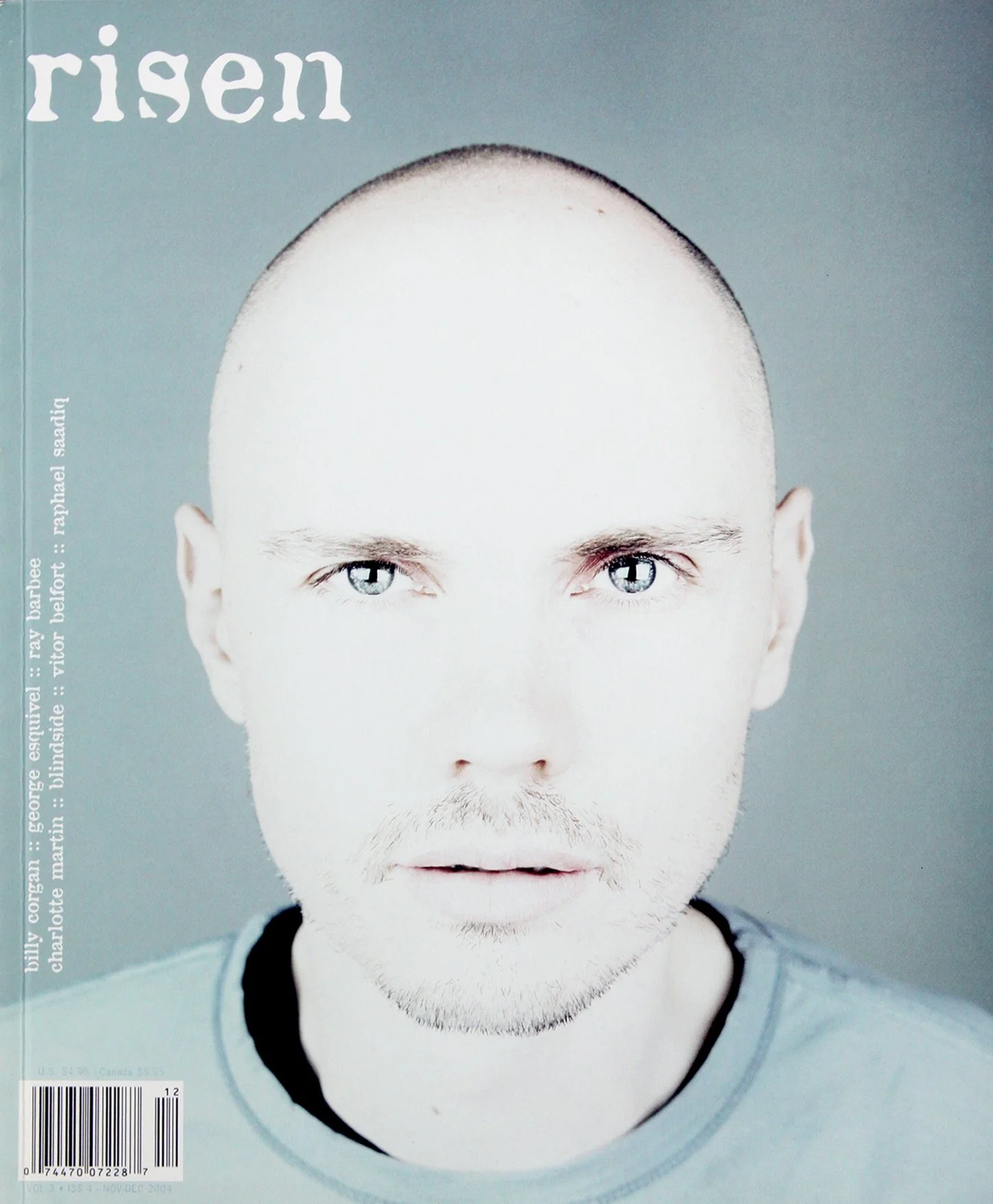 Close-up of a man with a shaved head and blue eyes on the cover of a magazine with the word 'rissen' at the top.