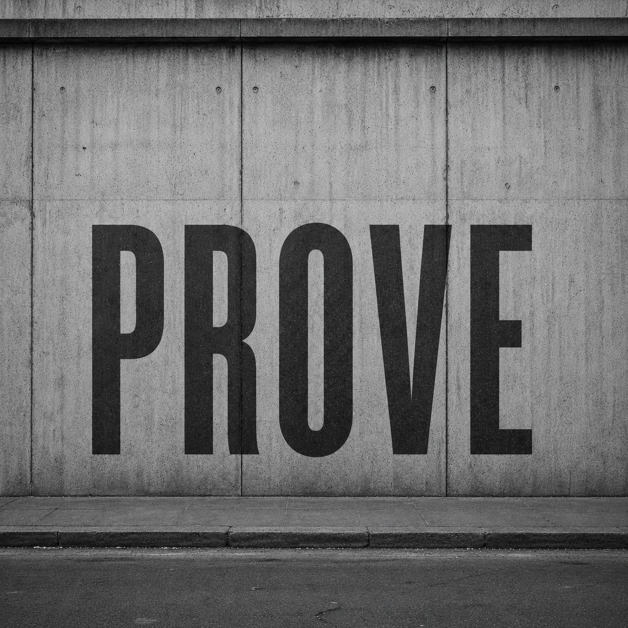 A concrete wall with large black letters spelling 'PROVE' painted on it.