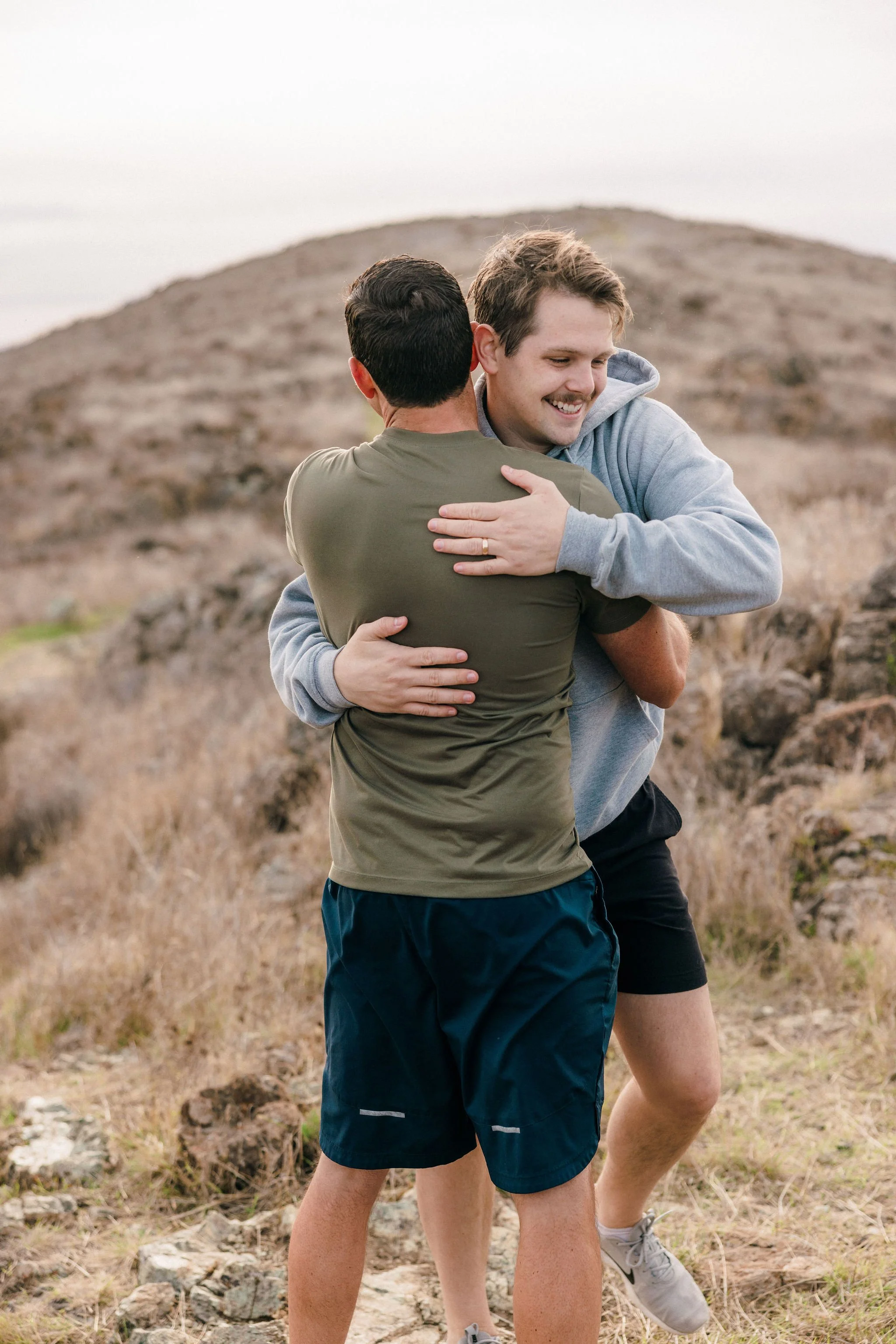 Two men embracing outdoors representing brotherhood, support, and shared commitment.