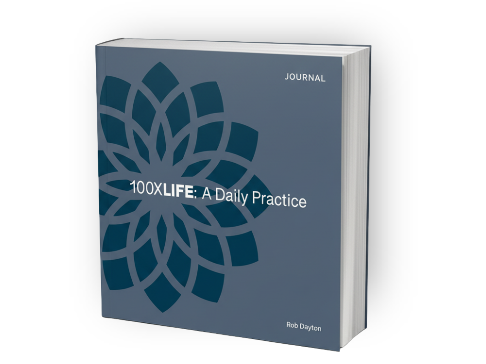A gray hardcover journal titled '100X LIFE: A Daily Practice' by Rob Dayton, featuring a blue geometric floral design on the cover.