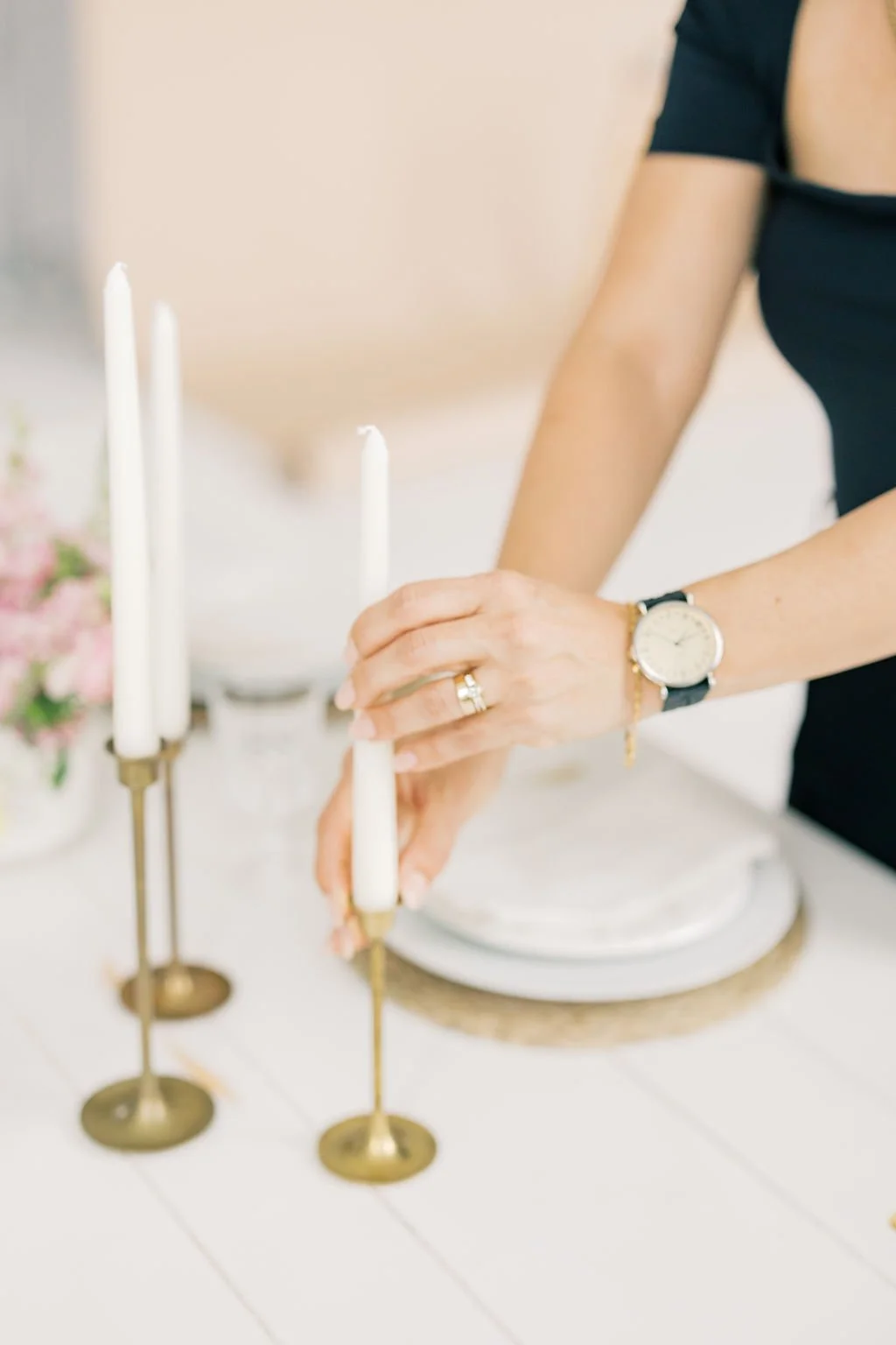 Berenice Ratcliff of Margo Events adjusting taper candles during wedding table styling.