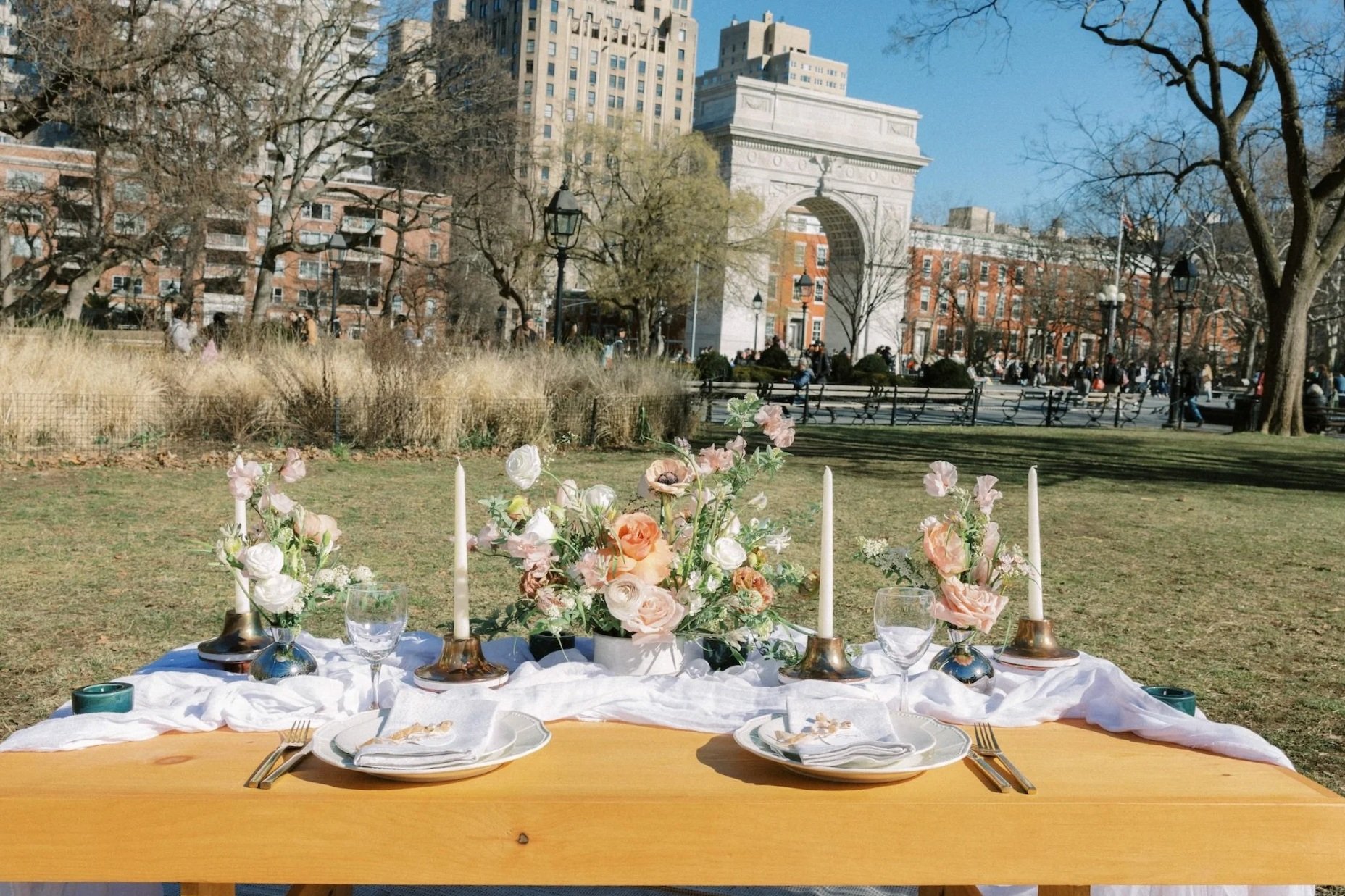 Styled luxury picnic setup with floral centerpieces in Washington Square Park, New York City, perfect for intimate celebrations and engagement parties