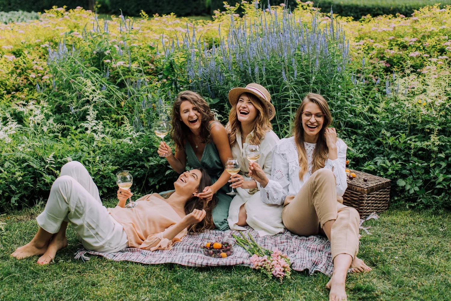 Group of women relaxing outdoors with wine, representing stress free wedding planning support from a professional planner.