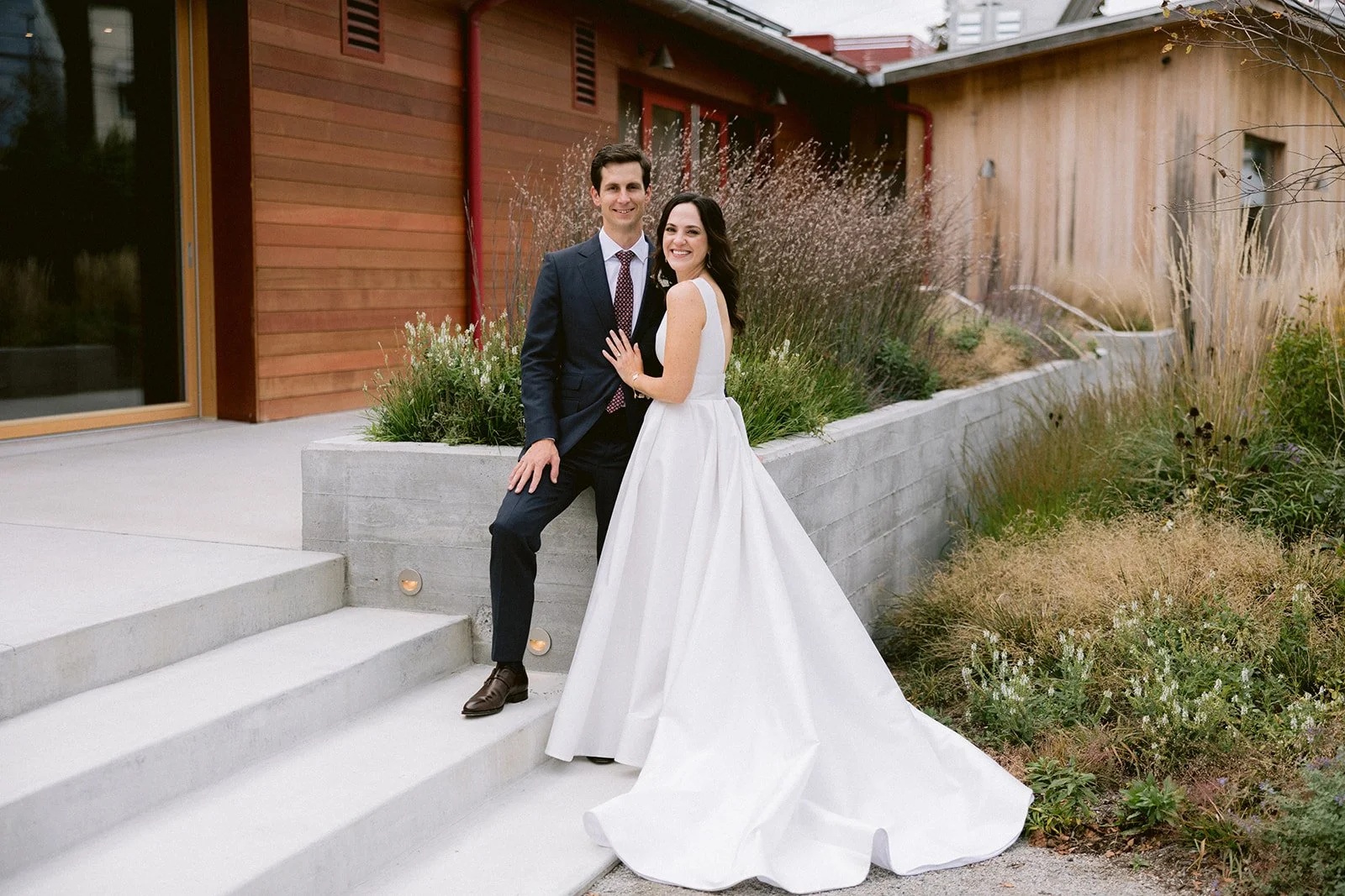 Bride and groom posing outside a modern Hudson Valley The Caboose wedding venue.