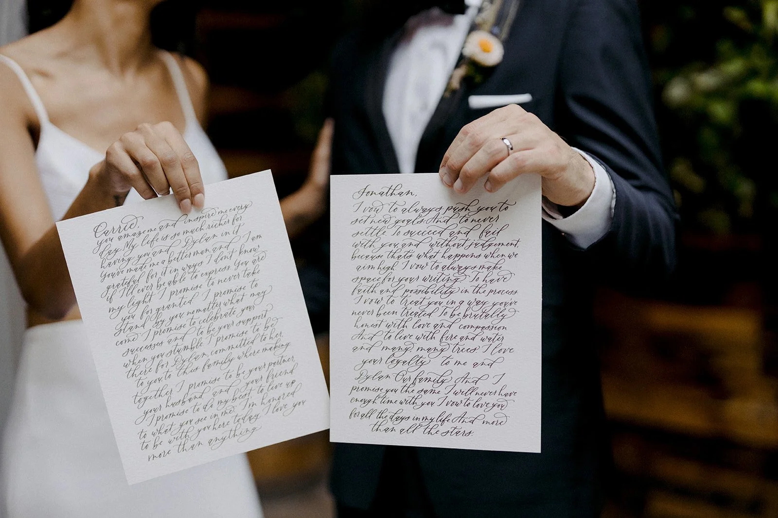 A bride and groom holding handwritten vows at their wedding ceremony.