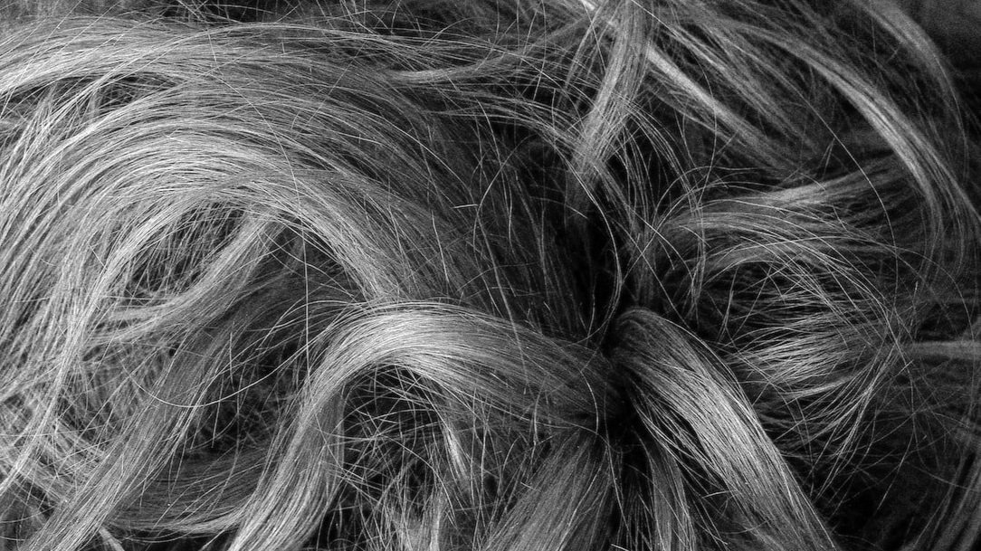 Close-up of gray hair with blonde highlights and loose curls.