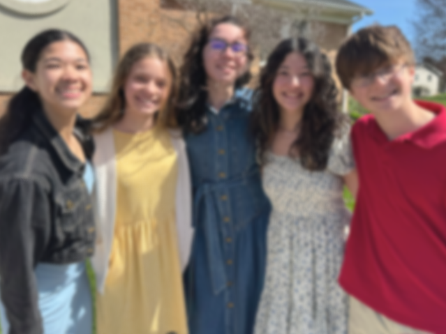 Good News Baptist Church Grand Rapids Michigan Five young friends smiling outdoors in front of a house, standing close together.