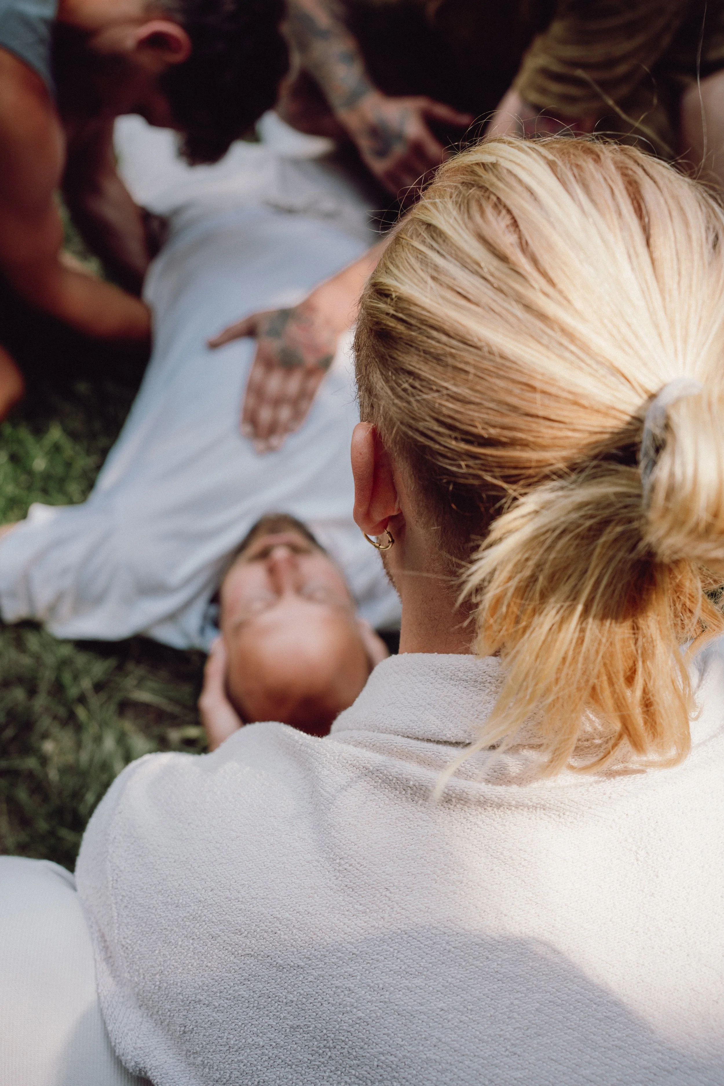 Menschen bei einer Ersten-Hilfe-Übung, bei der eine Person die Atemwege freimacht, während eine andere Person eine andere Person am Boden betreut.