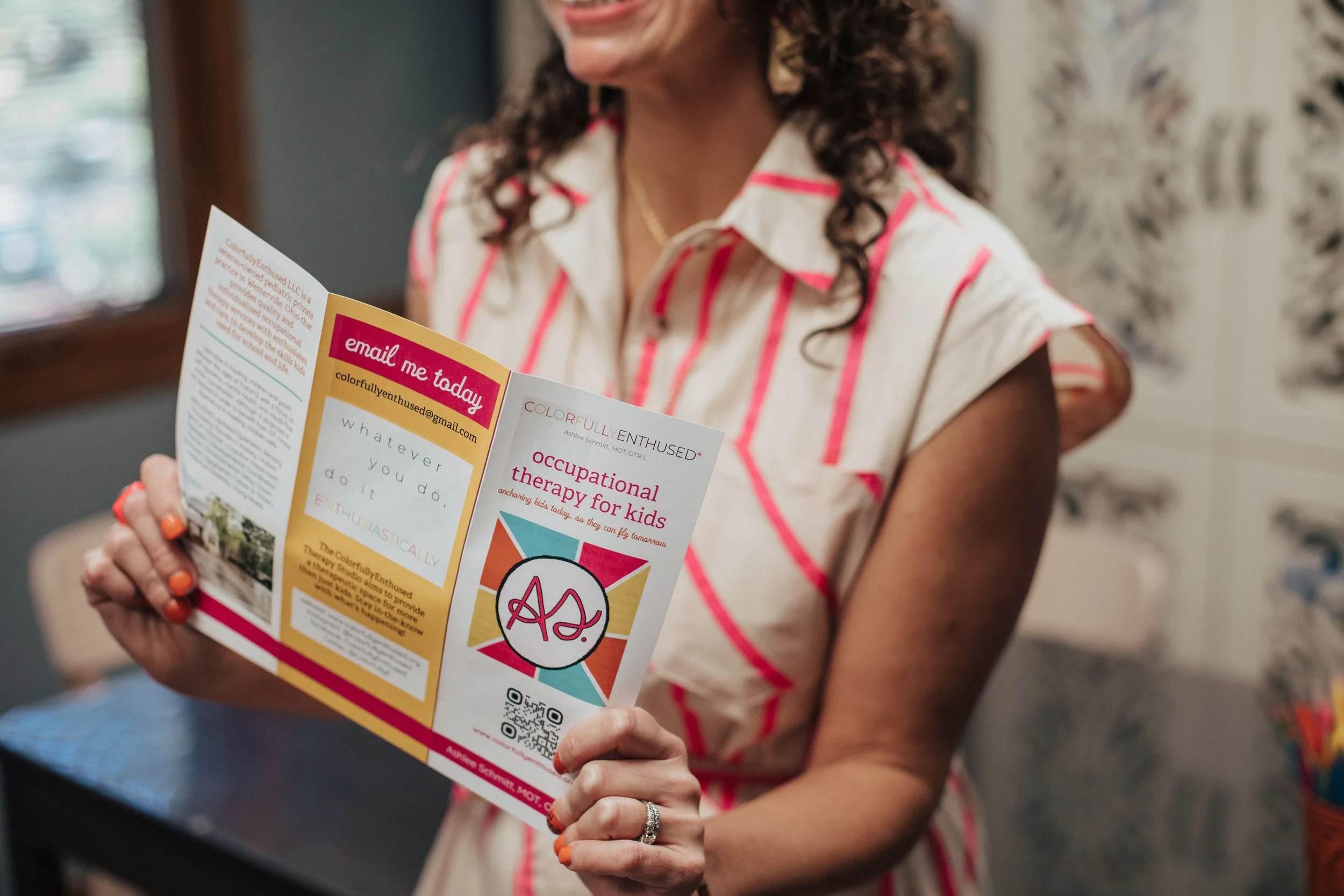 Occupational therapist in Columbus, OH holding a colorful flyer about occupational therapy for kids.