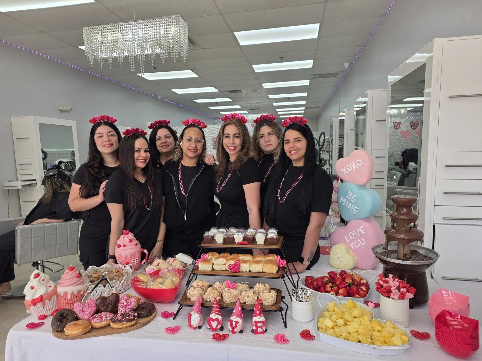 Group of women celebrating Valentine's Day with desserts and cake in salon