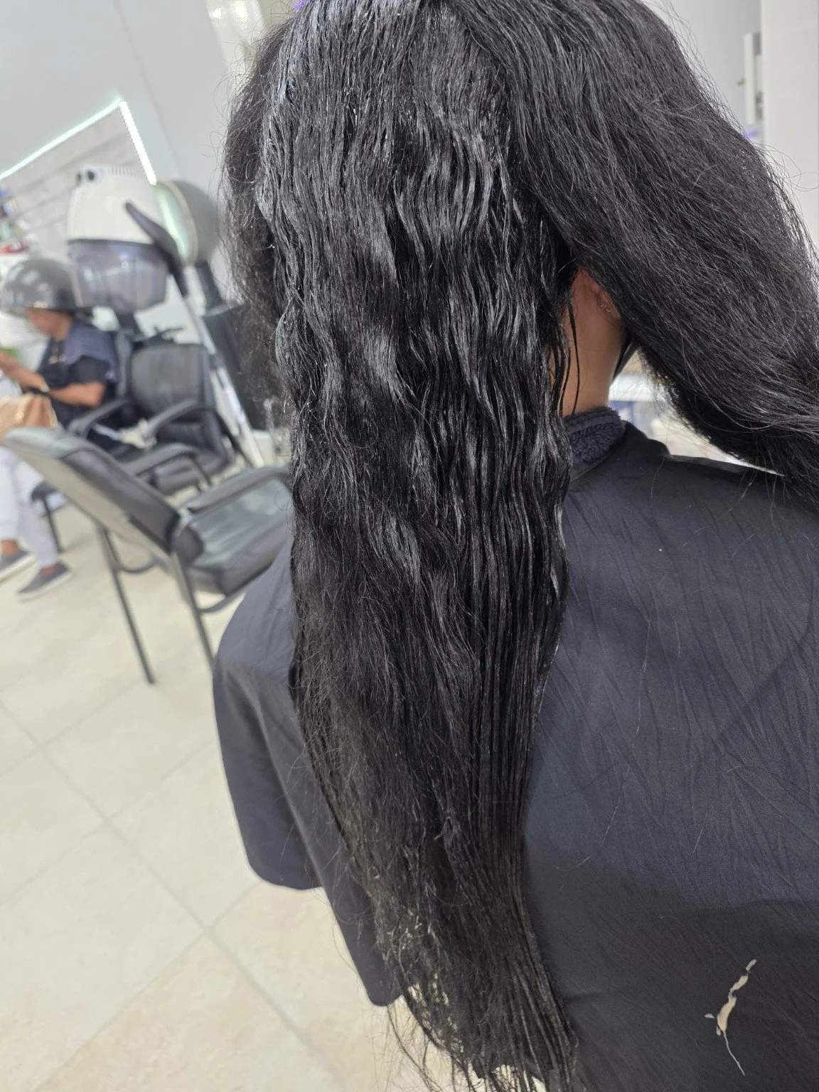 Woman in salon with long, wet black hair