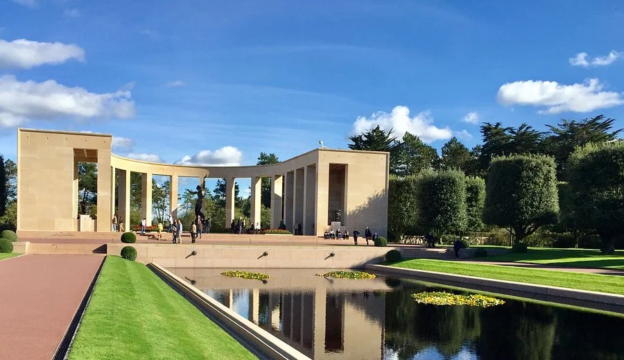Lincoln Memorial in Washington, D.C., with reflecting pool and trees in the foreground, under a blue sky with clouds.
