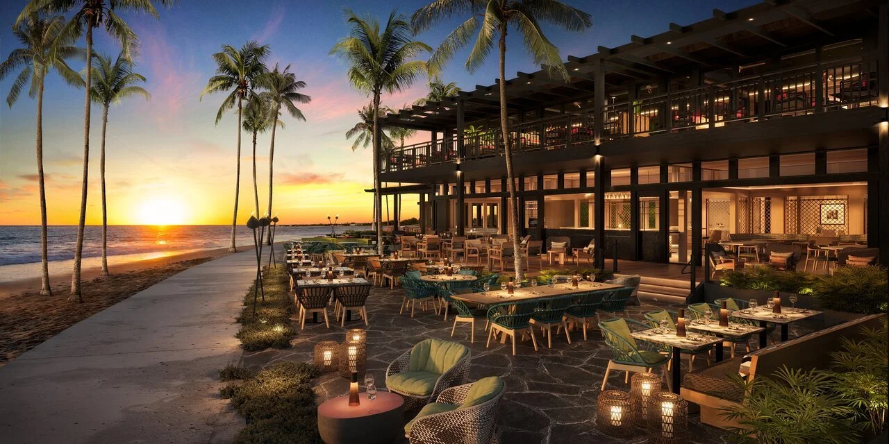 Beachside restaurant at sunset with palm trees, outdoor dining tables, and ambient lighting.