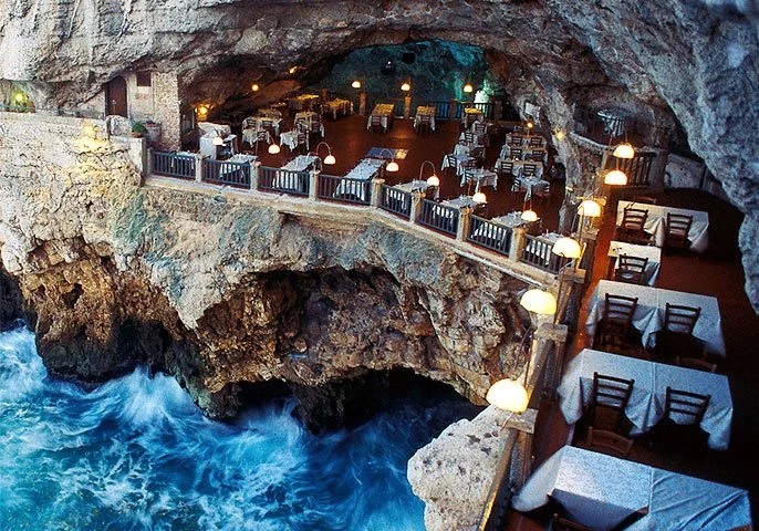 sea cave restaurant puglia Italy rocky cave dinner tables splashing ocean water against the rocks