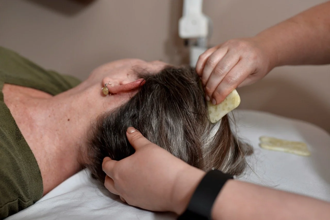 Person receiving a massage or physical therapy on the neck and head with a sponge