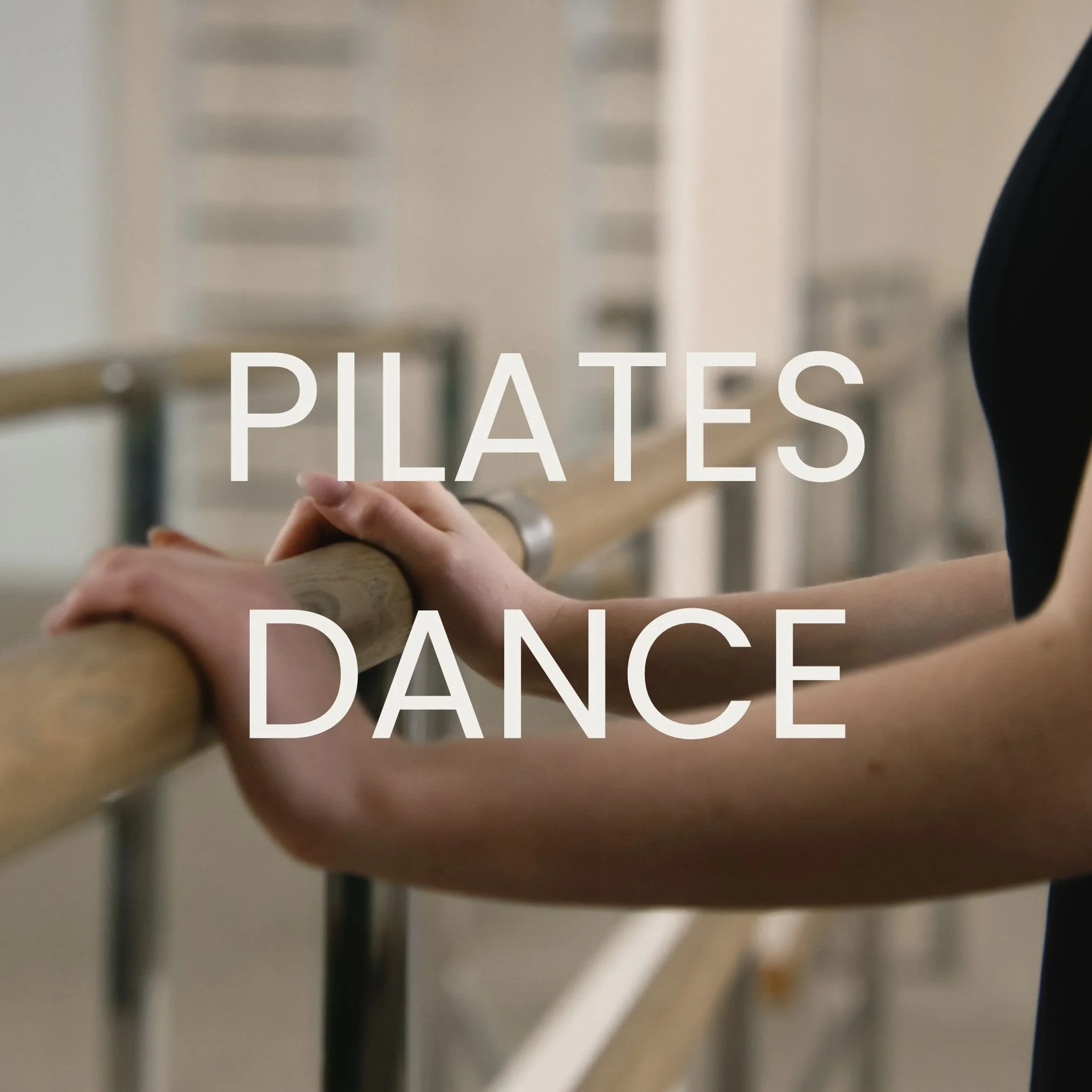 Person holding onto ballet barre with the words "Pilates Dance" overlaid.