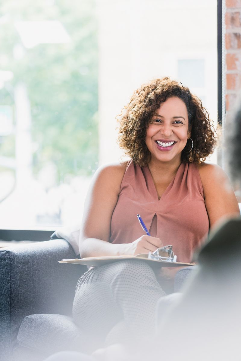 Women smiling on the couch with pen and paper