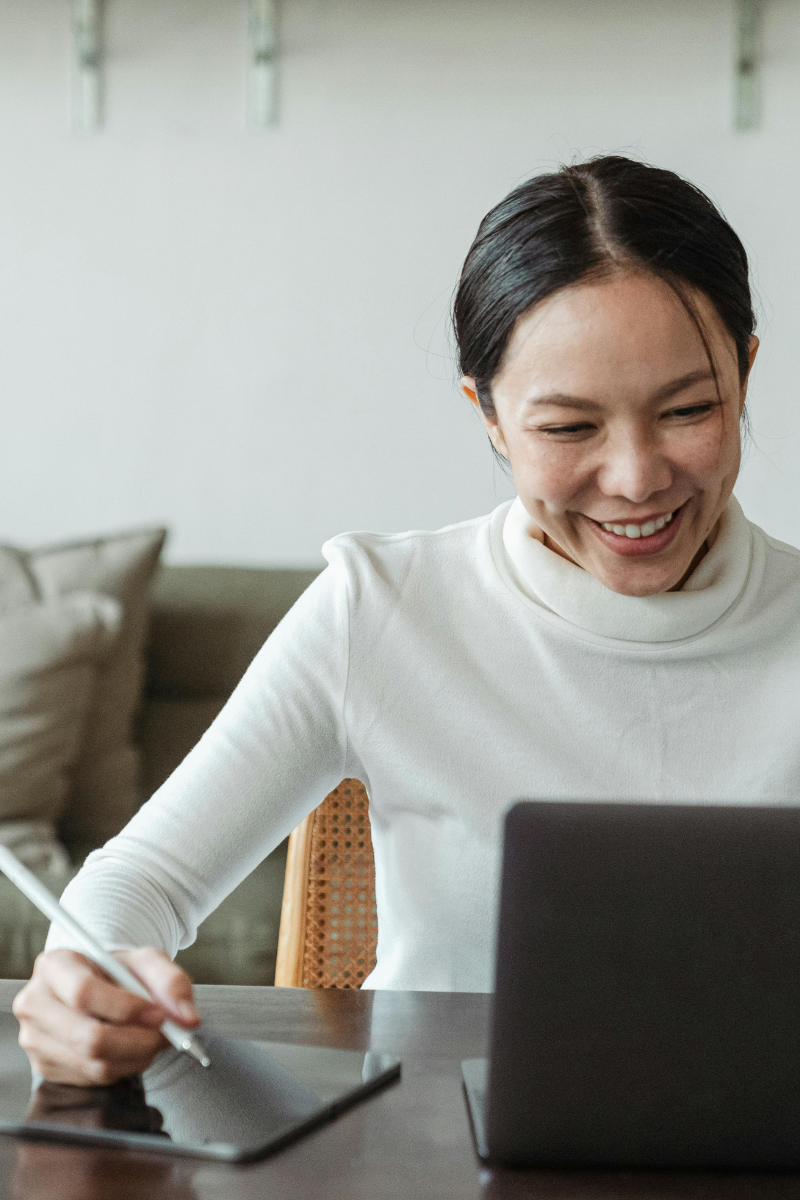 Women sitting at desk smiling on her computer