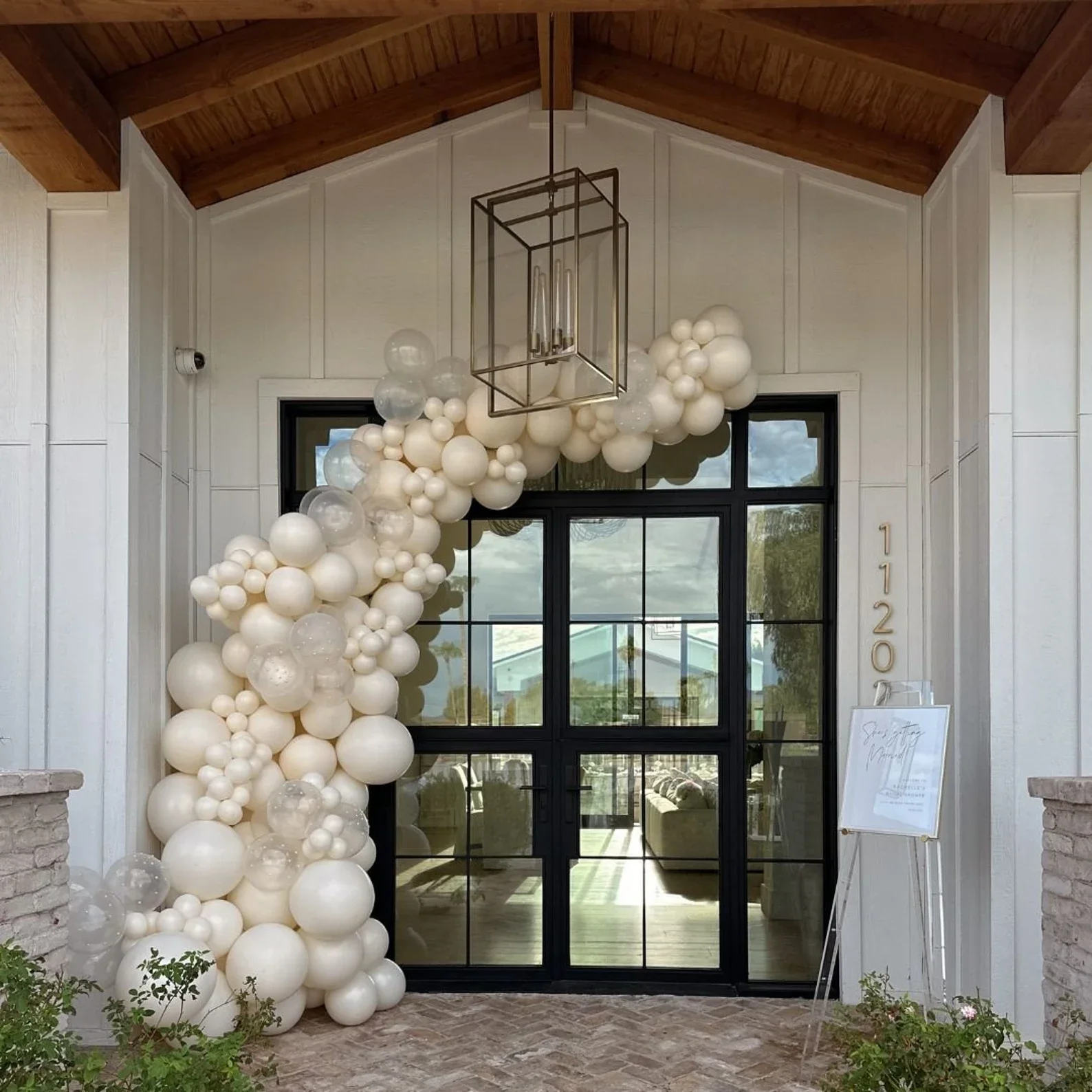 Bridal shower organic balloon garland installation in white, pearl white, and silver for event decoration in Omaha.