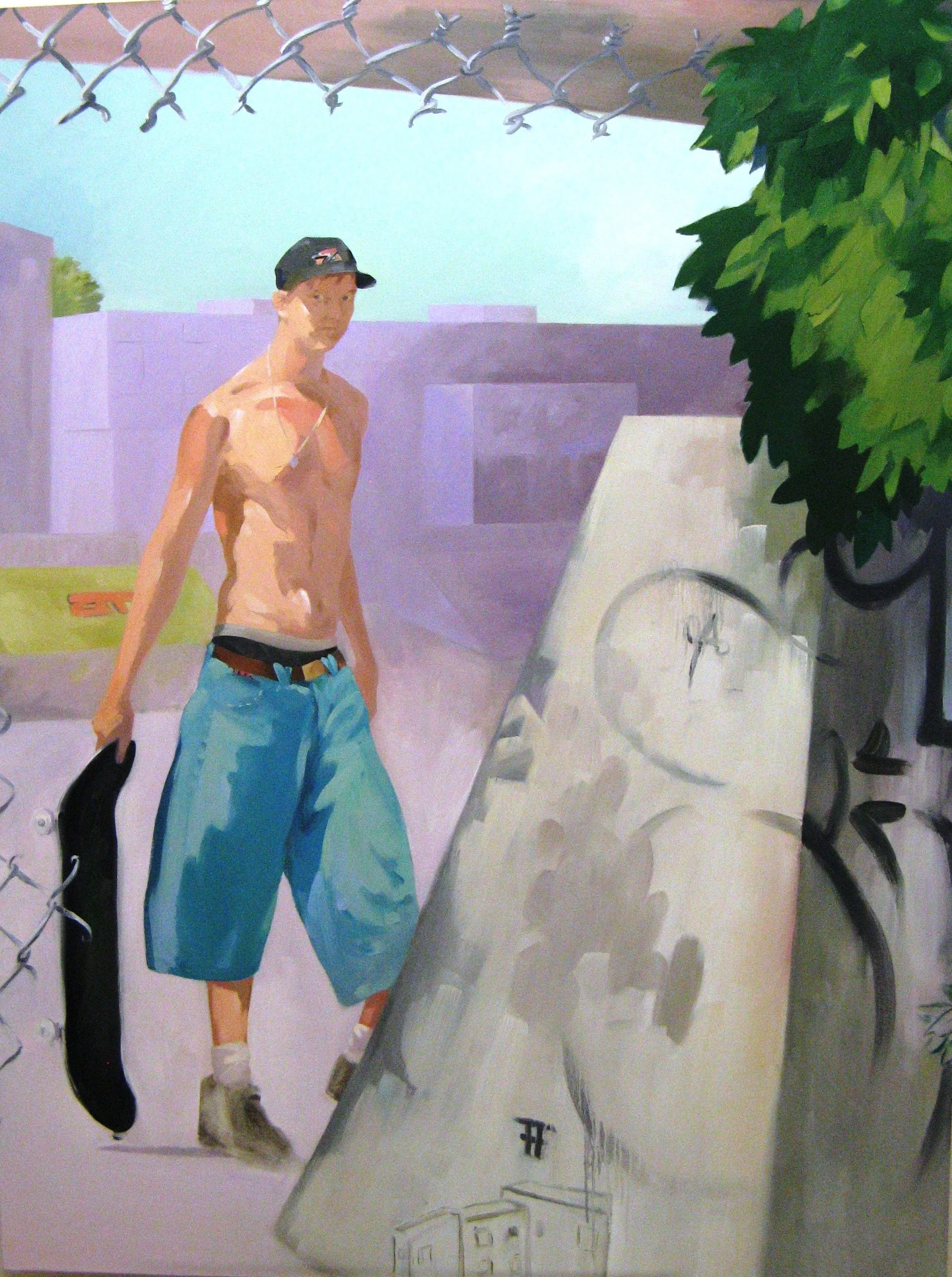 A young skate boarder is looking at viewer from behind a ramp.