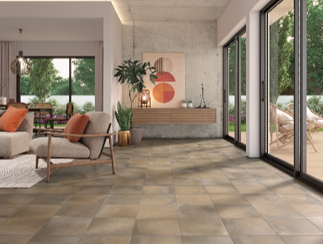 Modern living room with large sliding glass doors, beige tiled floor, and a wall with abstract art and plants.