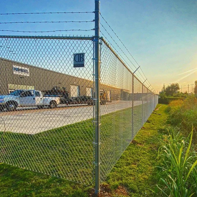 Chain link security fence with barbed wire around a commercial lot in Northwest Arkansas.