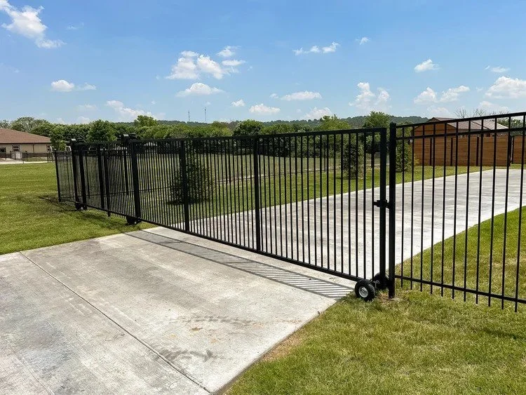 Black steel fence with a rolling drive gate.