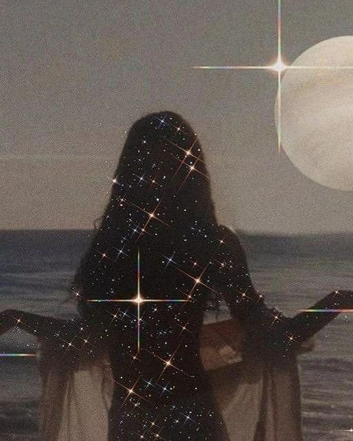 A person with long hair standing on a beach at night, with a starry overlay and a large moon in the sky.