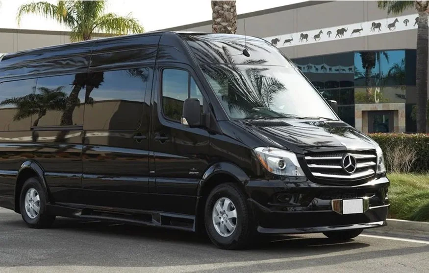 Ghost Sedan's Mercedes Sprinter 9 passenger van parked in front of a building