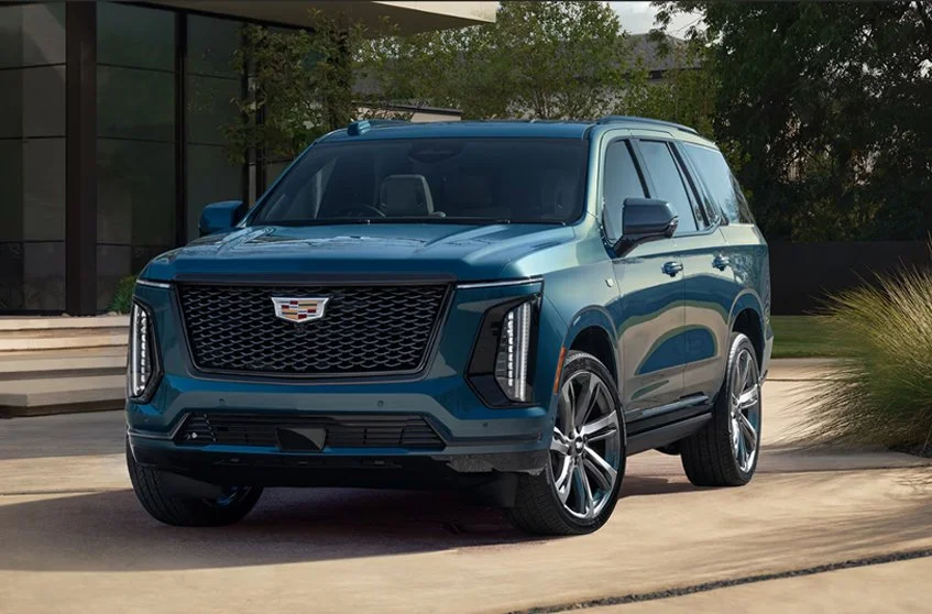 Ghost Sedan's Cadillac Escalade SUV parked in front of a modern house