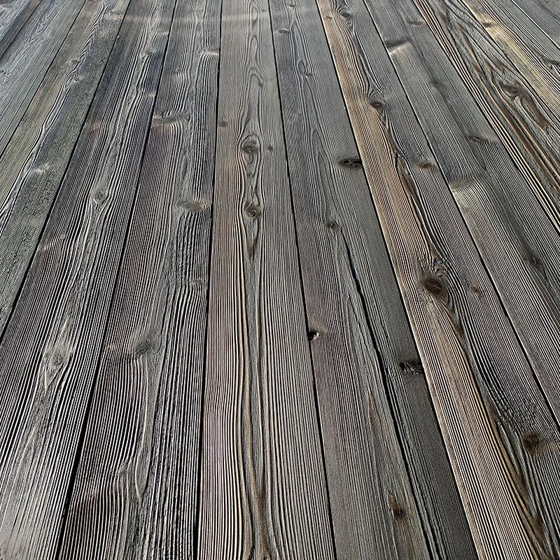 Close-up view of charred, brushed and oiled wooden floorboards showing distinct wood grain patterns.