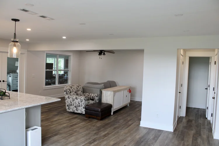 Open-plan living area and kitchen with white walls and trim