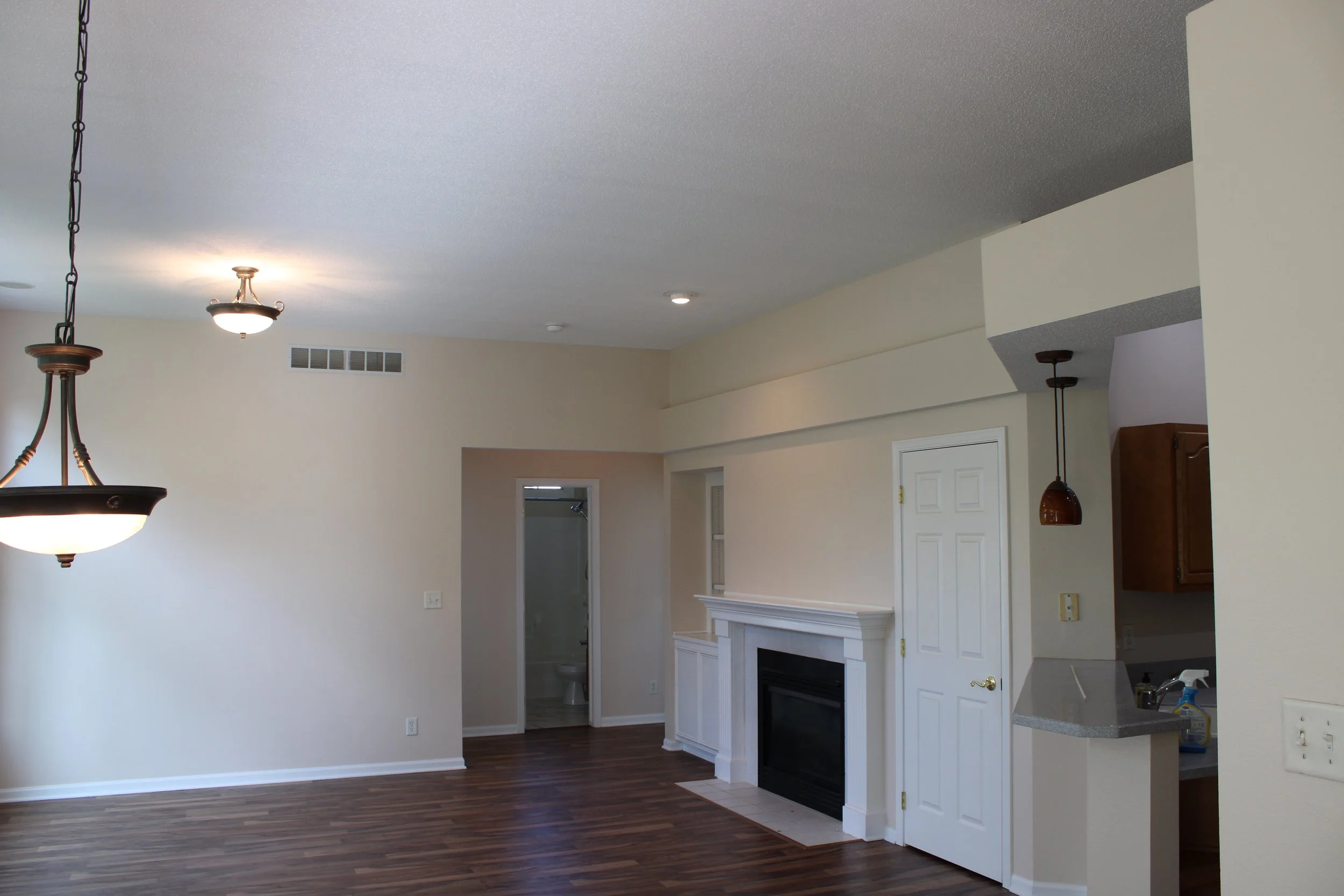 Johnston townhouse interior painted by Mission Painting: light walls, white trim and white fireplace surround