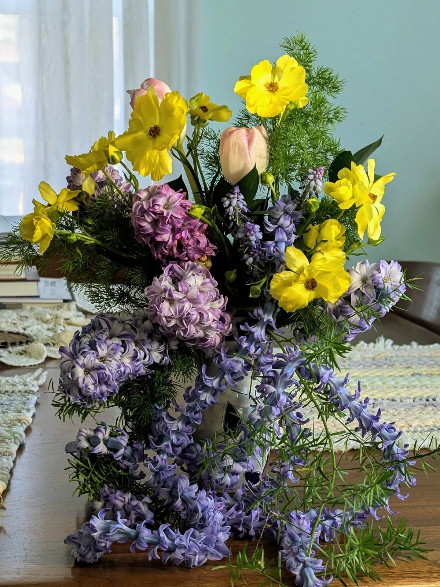 Spring is a state of mind
Mud is as essential as flowers 
Where thunder and snow clash
And the wind sweeps away
All that has been shed

Hyacinth strands on mossy ferns, while butter colored butterflies [ranunculus] float overhead in this bouquet that