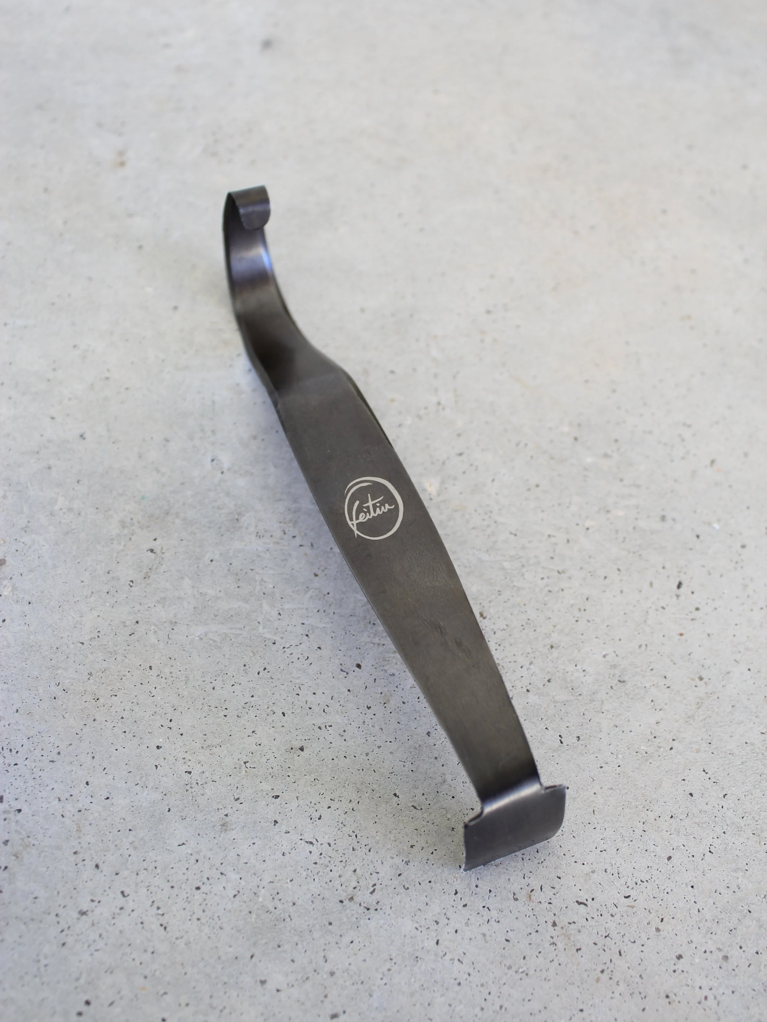 Vista de cima da Ferramenta AC-01 com acabamento anti-oxidação em aço carbono sobre superfície neutra - Handmade Pottery Tool - Feitiu