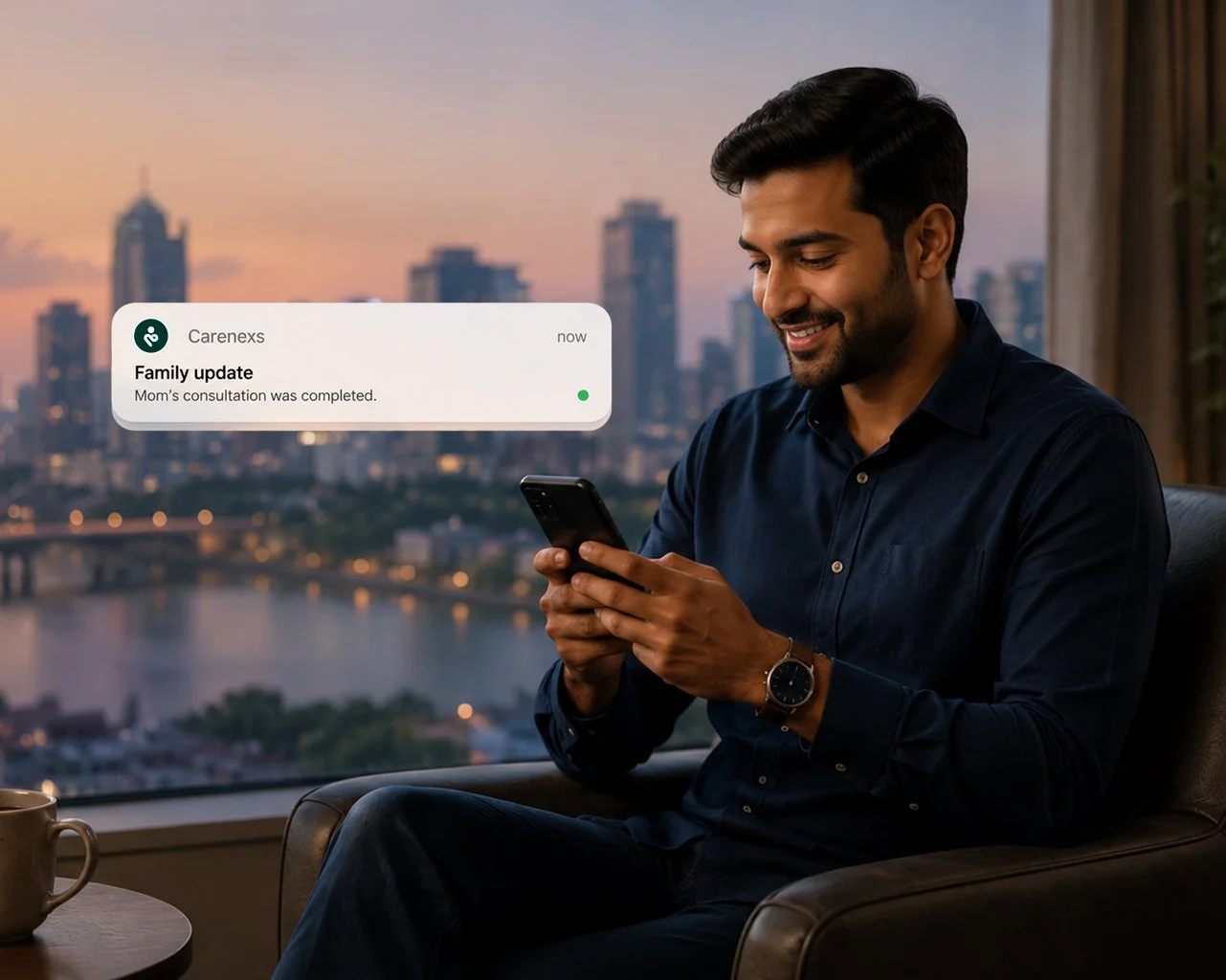 A man sitting on a couch in a city apartment, looking at his phone with a smile. A notification on the phone shows a family update about a mom's consultation being completed, with a city skyline at sunset in the background.