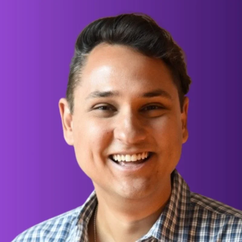 A person with short dark hair smiles, placed against a purple background.