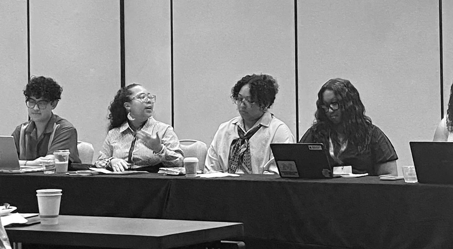 Erykah Benson presenting research at the Hawaii International System Sciences Conferences with co-presenters Gabe Paredes, Jasmine Banks, Kyla Brathwaite, Apryl Williams, Janae Sayler, and Mel Monier